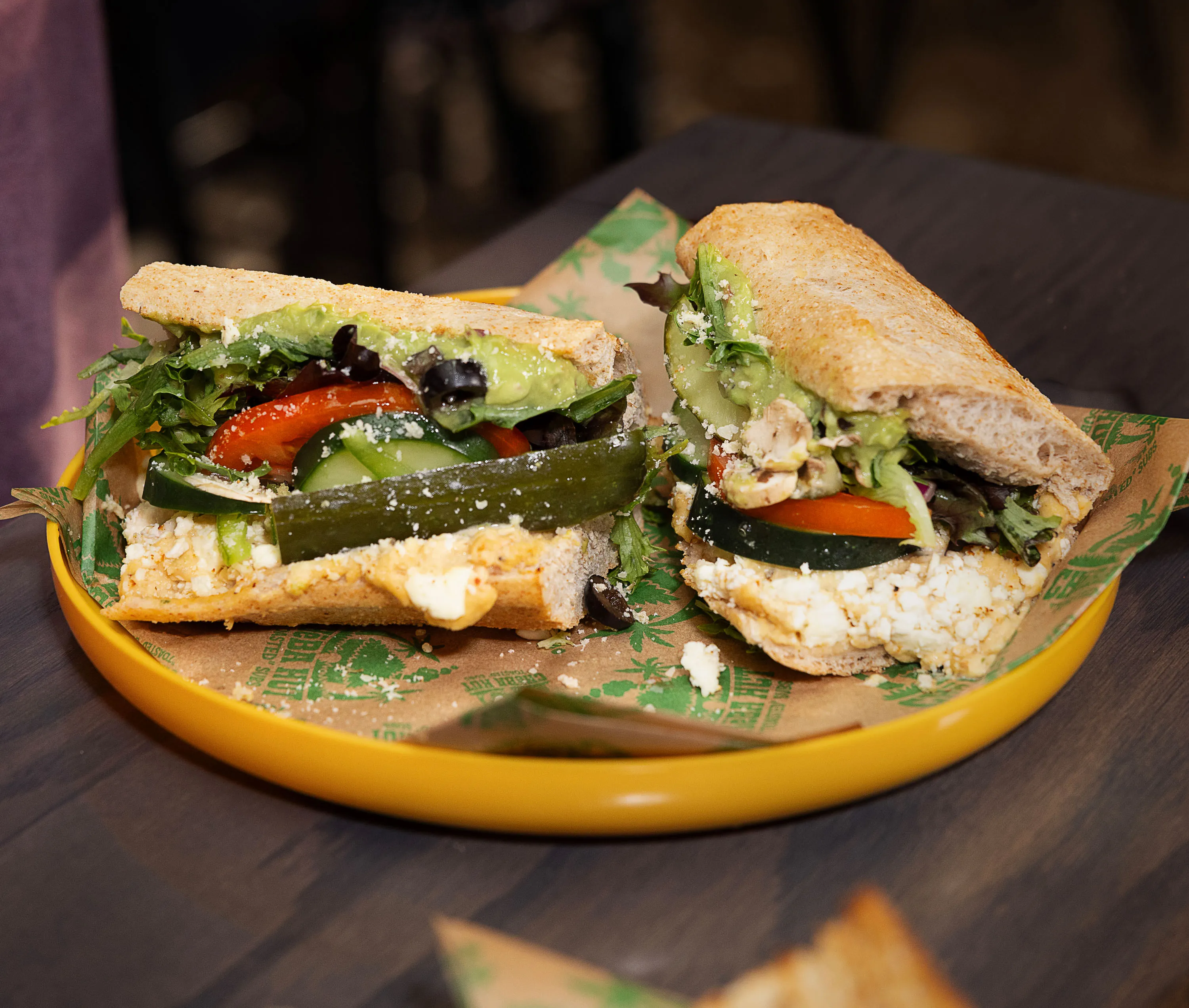 Toasted vegetable subs with lettuce, tomato, cucumber, olives, and avocado