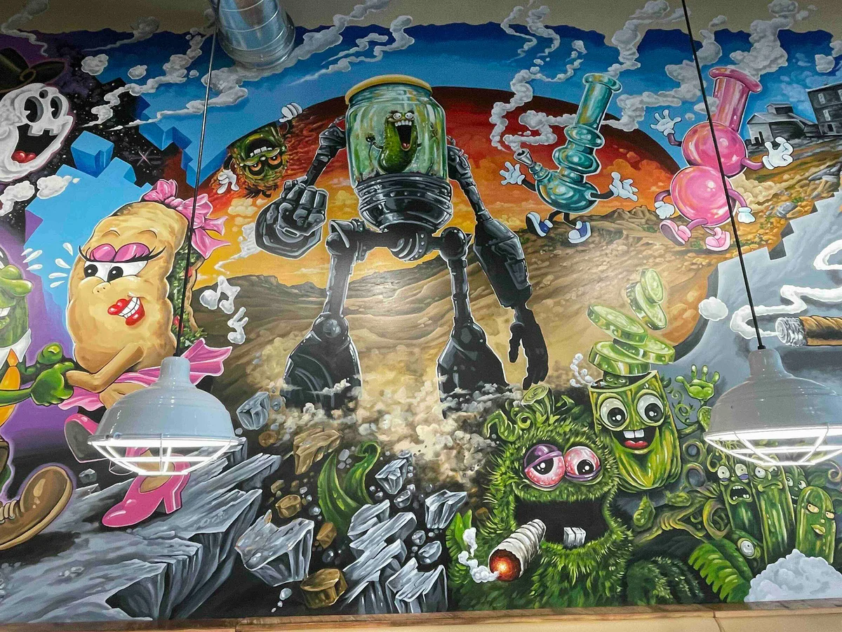 A mural of a robot pickle in a jar and other characters smoking weed