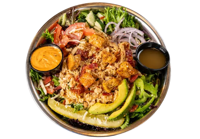 Kali Mist salad with grilled chicken, bacon, avocado, vegetables, and dressing