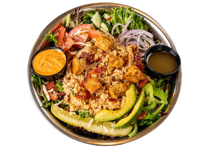 Kali Mist salad with grilled chicken, bacon, avocado, vegetables, and dressing