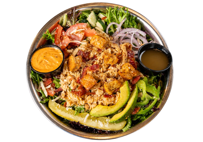 Kali Mist salad with grilled chicken, bacon, avocado, vegetables, and dressing