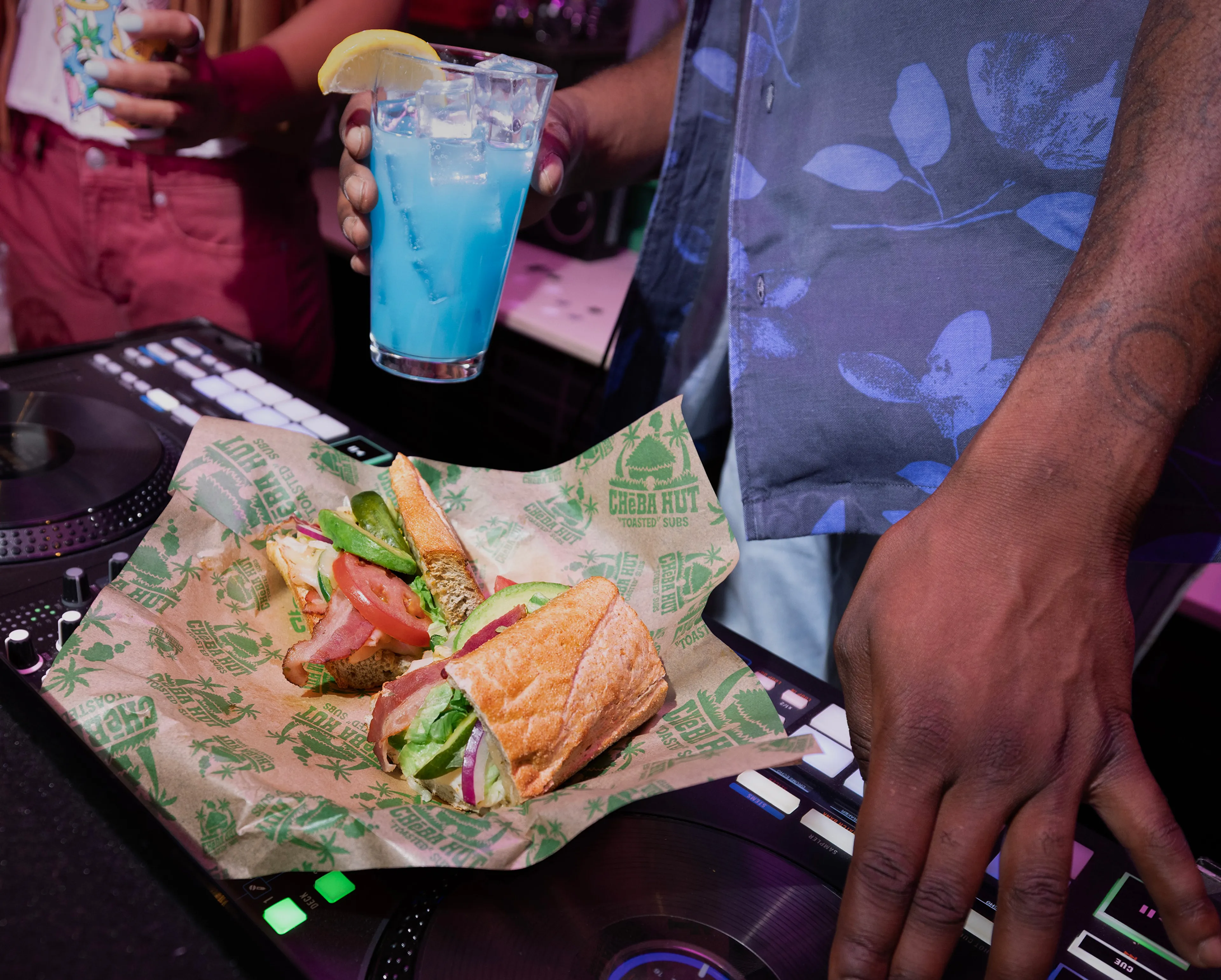 Cheba Hut sub and blue cocktail beside DJ turntables
