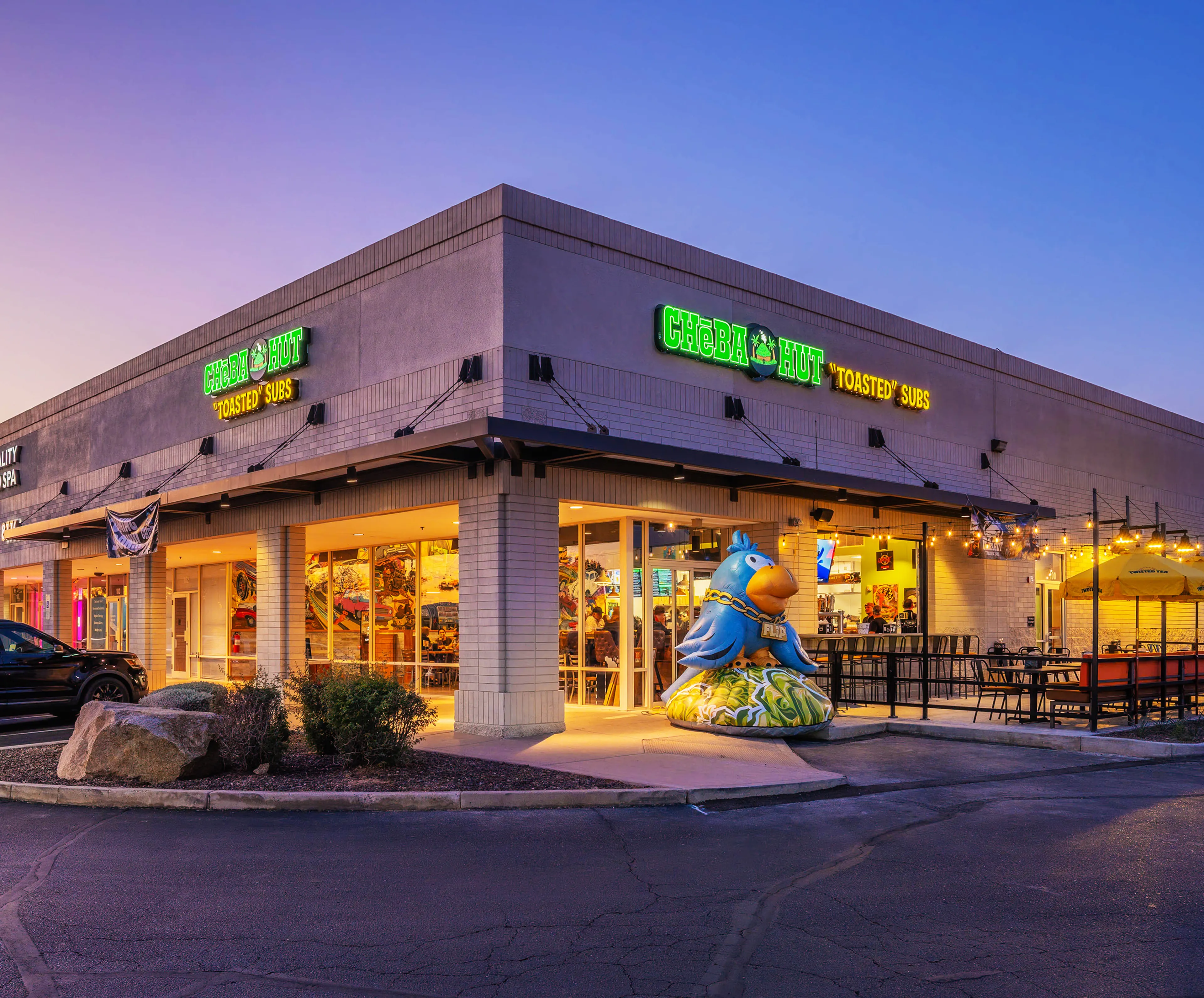 Cheba Hut shop exterior with lit sign at sunset