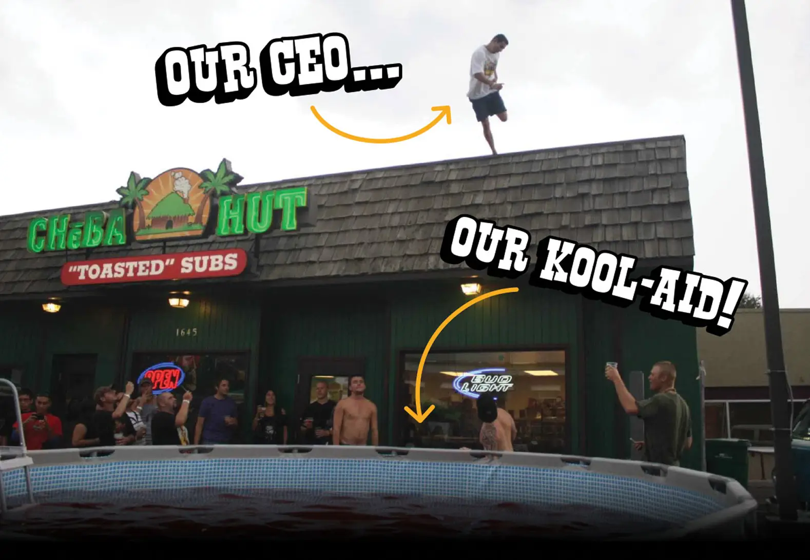 A man stands on the roof of a Cheba Hut "Toasted" Subs shop above a cheering crowd and an above-ground pool full of red Kool-Aid. Hand-drawn captions with arrows: "Our CEO..." points to the man on the roof, and "Our Kool-Aid!" points to the pool.